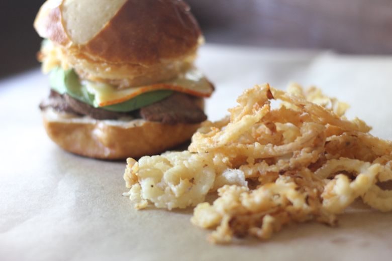 Steak Sandwich with Onion Straws next to it.