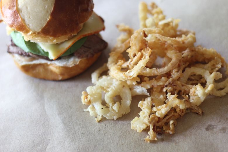 Steak Sandwich with Onion Straws next to it.