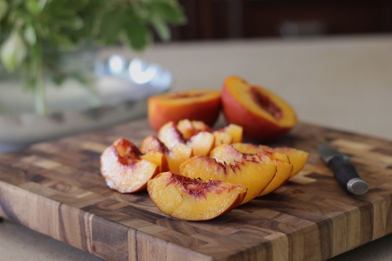 Sliced peaches on a cutting board.