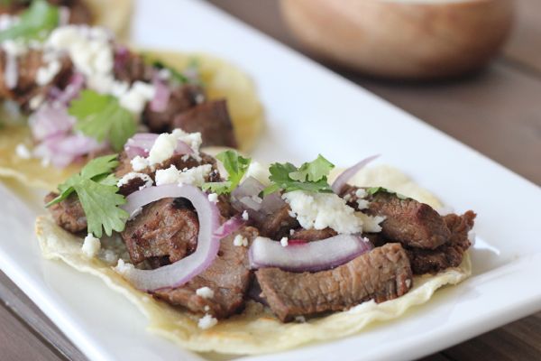 Grilled steak, red onions, and queso fresco on a lightly fried white corn tortilla.
