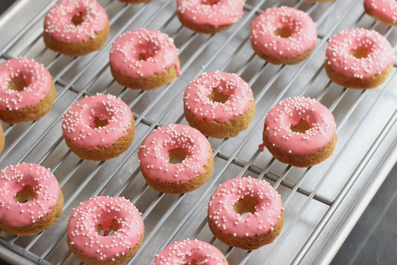 Sugar Cookie Donuts drying on a cooling rack.