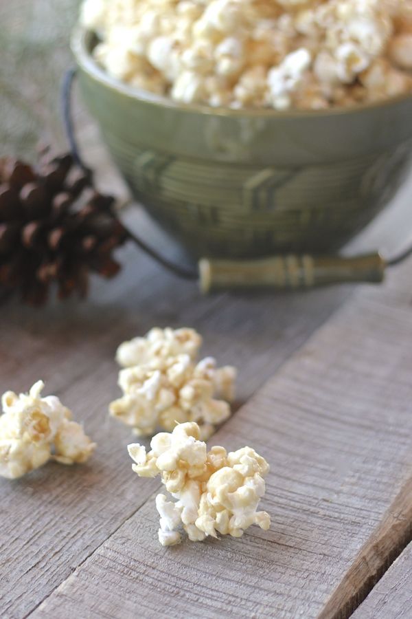 No Bake Caramel Corn in a bowl with a few pieces on a board.