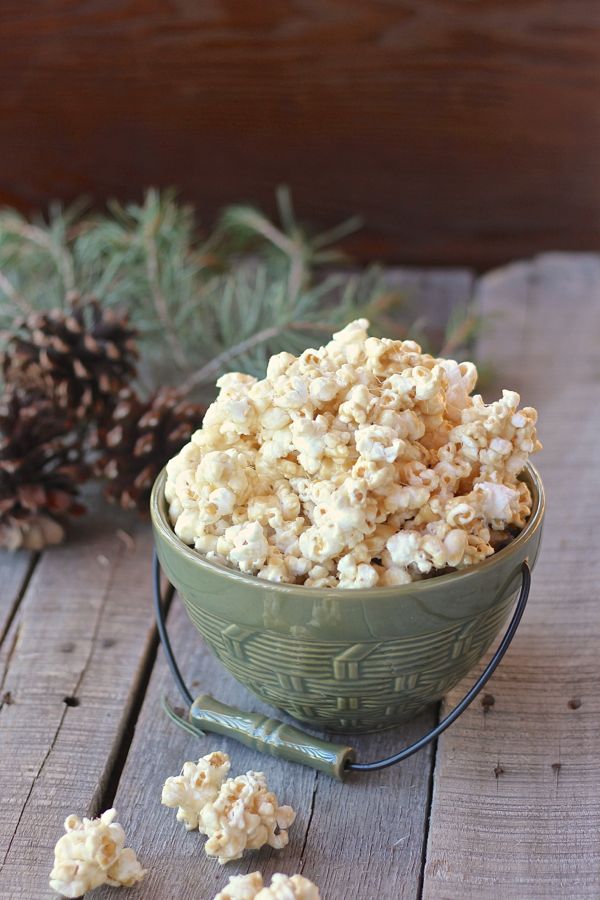 No Bake Caramel Corn in a bowl with a few pieces on a board.