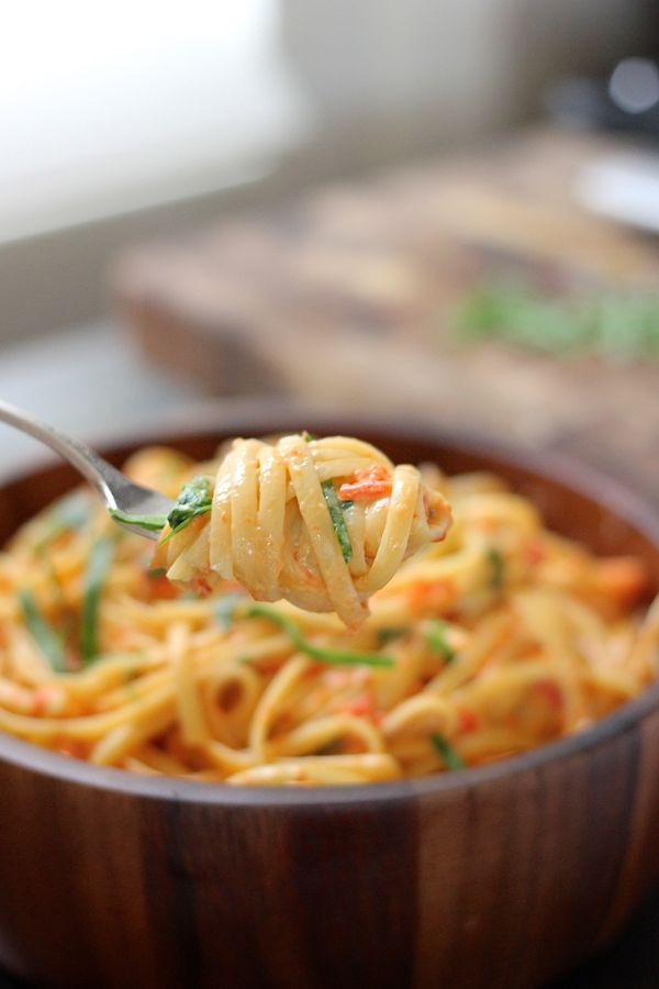 Creamy Roasted Red Pepper and Spinach Linguine twirled onto a fork.