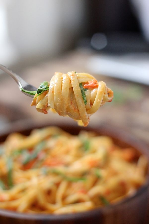 Creamy Roasted Red Pepper and Spinach Linguine twirled onto a fork.