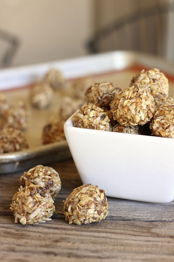 Honey Oat Energy Bites piled in a bowl with a few outside of the bowl.