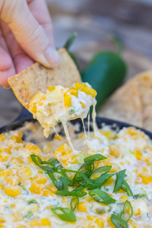 A tortilla chip dipped into the Hot Jalapeño Corn Dip.