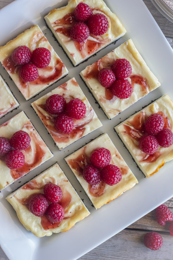 Raspberry Swirl Cheesecake Bars arranged on a serving plate.