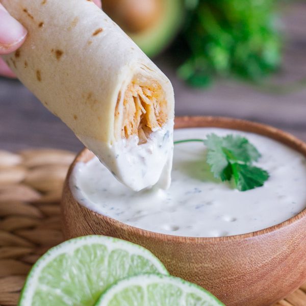 Sweet and spicy shredded chicken wrapped up in a crispy, crunchy baked tortilla with some Cilantro Lime Cream for dipping