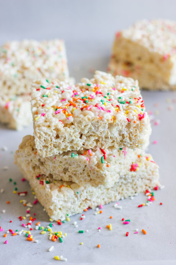 Coconut Oil Rice Krispie Treat squares with sprinkles stacked in a pile of three.  