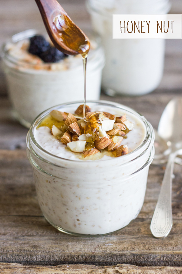 Overnight Steel Cut Oatmeal with almonds in a glass jar with honey being drizzled on top, and two other jars of Overnight Steel Cut Oatmeal in the background.  