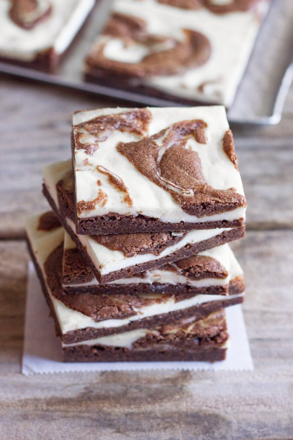 Cheesecake Swirled Fudge Brownies cut in squares and stacked in a pile of five.