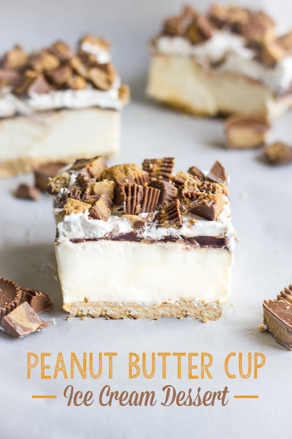 Peanut Butter Cup Ice Cream Dessert square piece with bits of peanut butter cups around it and two more square pieces of the dessert in the background.  