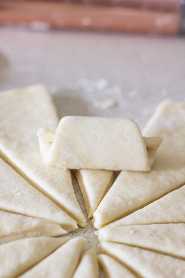 The Best Butterhorn Rolls dough wedge being rolled up.  