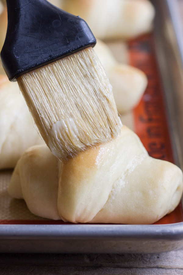 The Best Butterhorn Rolls being brushed with melted butter.  