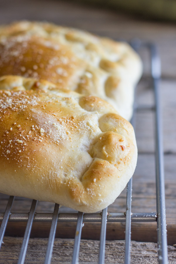 Homemade Calzones With Italian Sausage And Mozzarella on a cooling rack.  