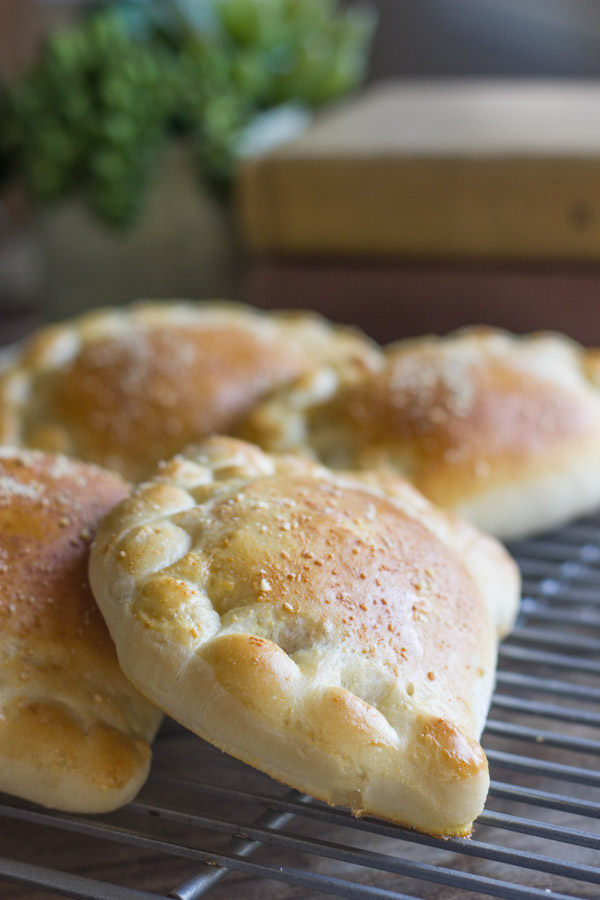 Homemade Calzones With Italian Sausage And Mozzarella on a cooling rack.  