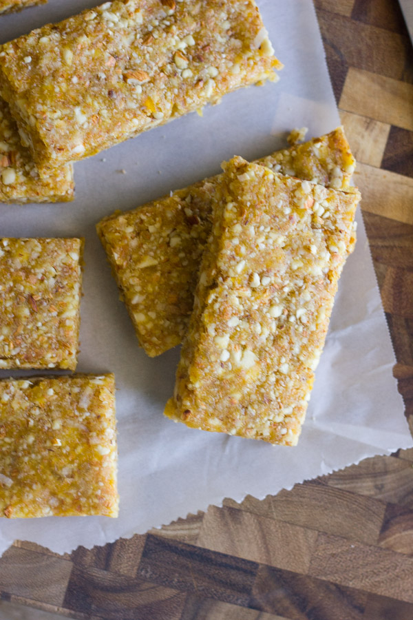 No Bake Apricot Almond Bars on parchment paper on top of a cutting bard.