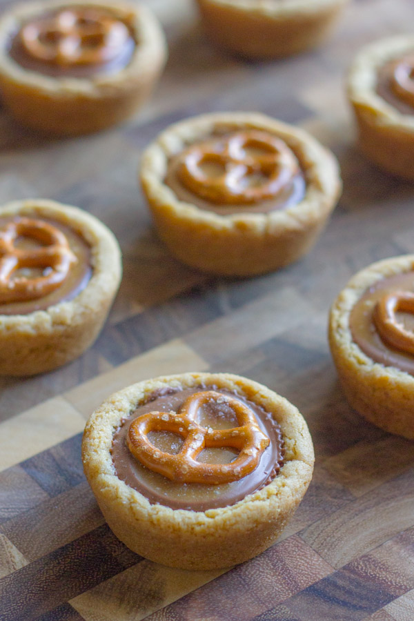 Peanut Butter Caramel Pretzel Cookie Cups on a cutting board.  