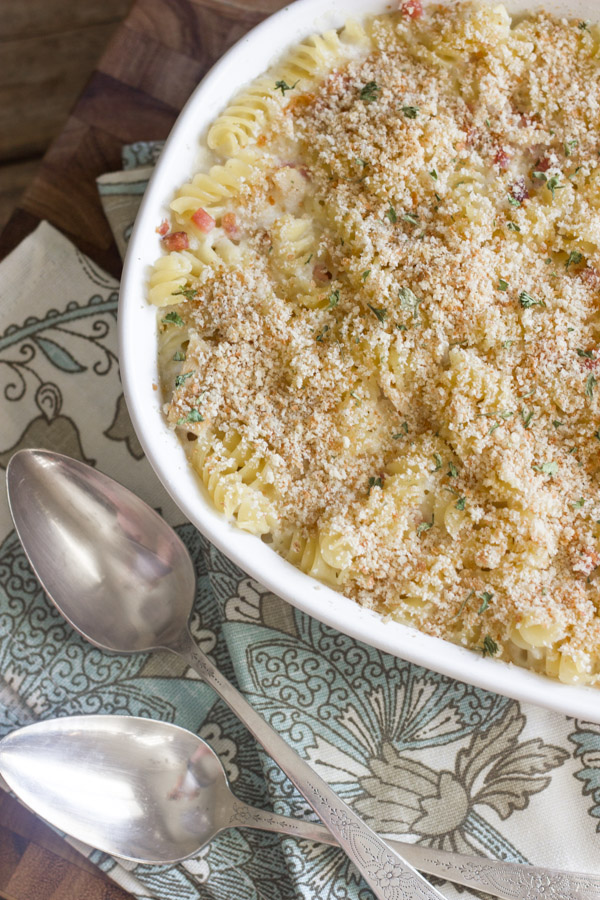 Chicken Cordon Bleu Pasta Bake in a baking dish, with cloth napkins and spoons next to it.