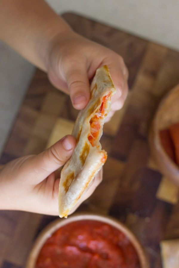 Waffled Pizza Pocket piece with a bite out of it.