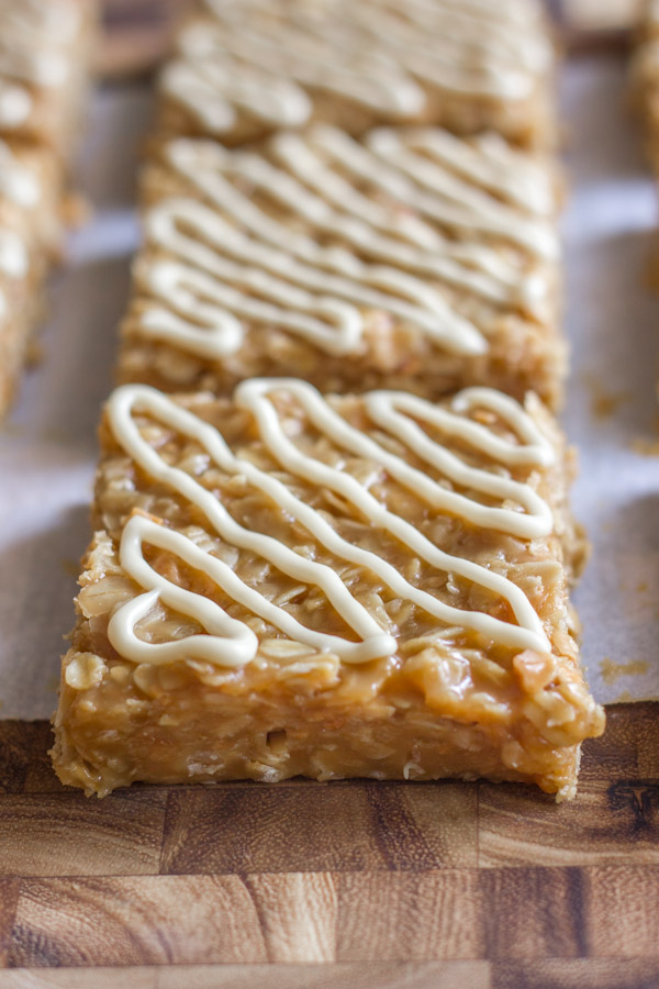 Maple Almond Oat No Bakes cut into squares on parchment paper on a cutting board.