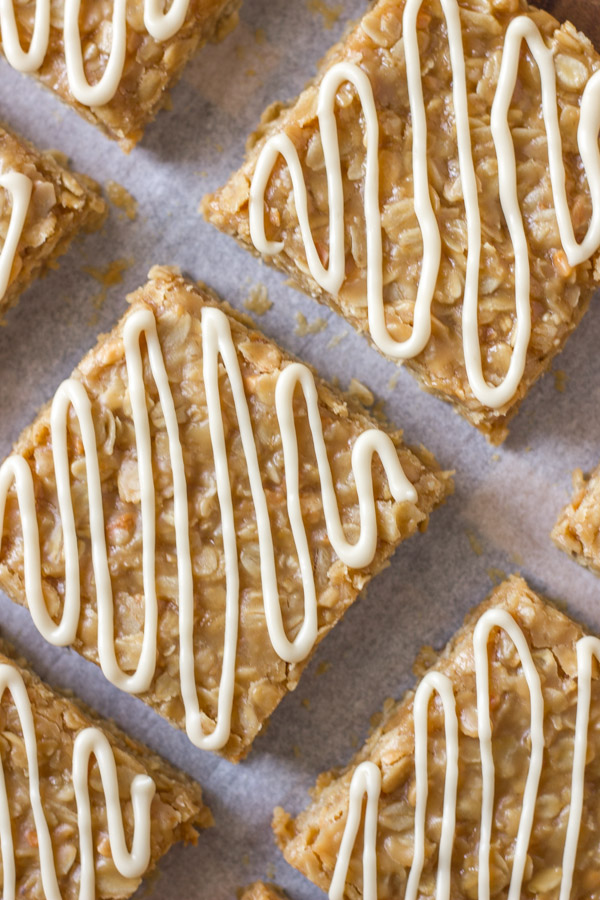 Maple Almond Oat No Bakes cut into squares on parchment paper on a cutting board.