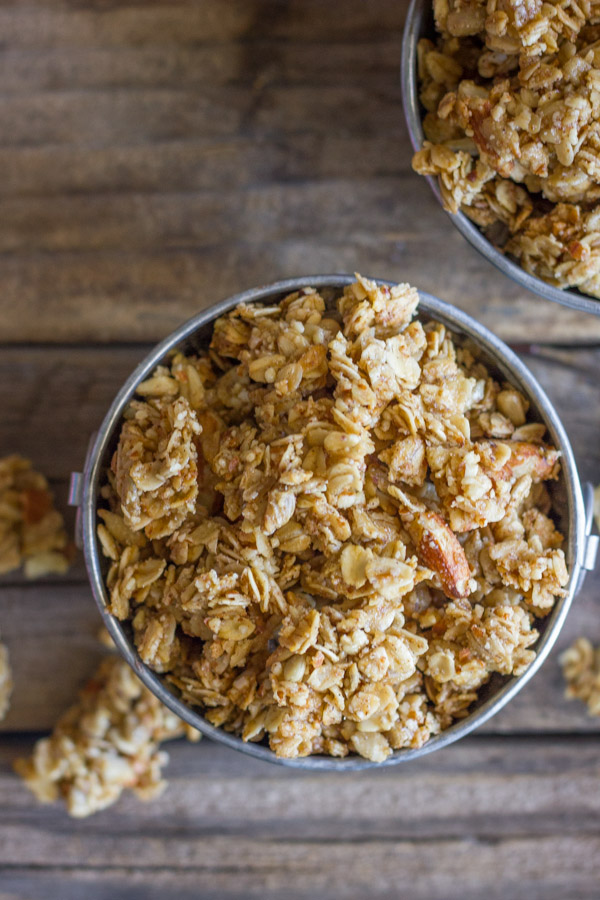 Pumpkin Pie Spice Coconut Oil Granola in two mini galvanized buckets, with some granola clusters next to the buckets.