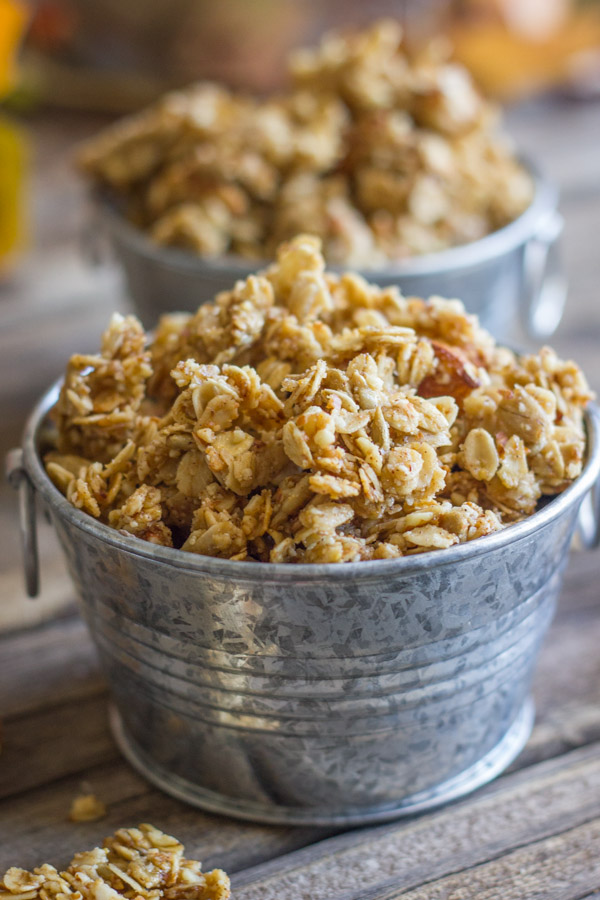 Pumpkin Pie Spice Coconut Oil Granola in two mini galvanized buckets, with some granola clusters next to the buckets.
