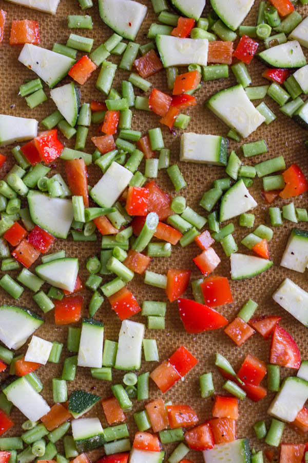 Chopped vegetables for Vegetable Tortellini With Creamy Garlic Sauce on Silpat lined baking pan.