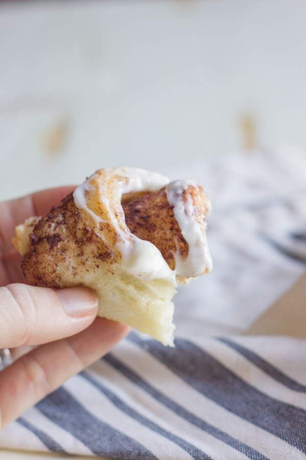 A piece of an Overnight Cinnamon Roll With Cream Cheese Frosting.