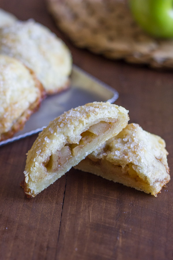 Apple Hand Pie cut in half, with more Apple Hand Pies in the background.