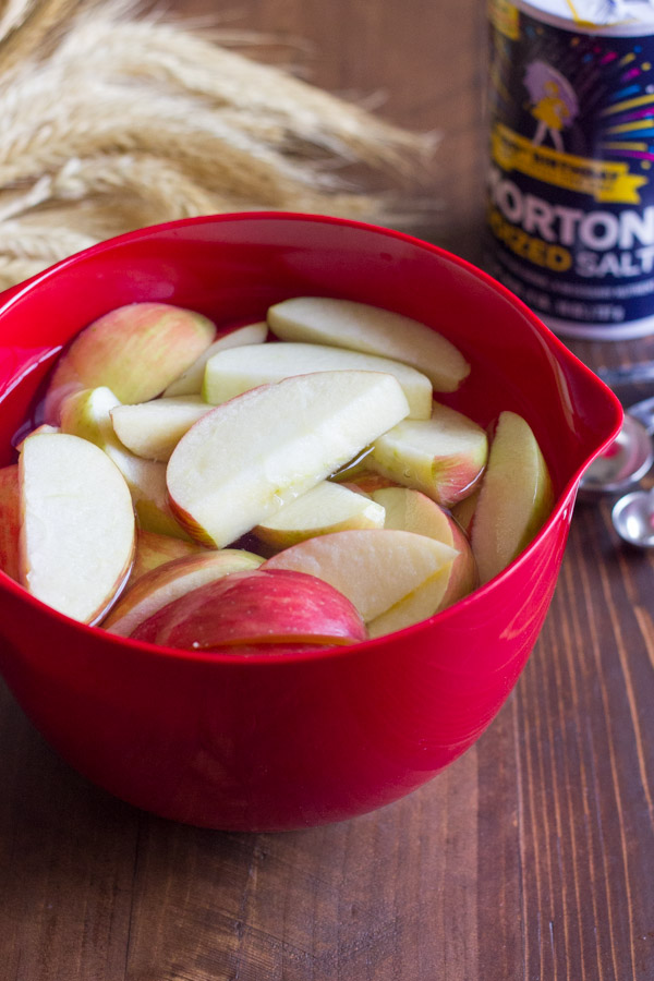Apple slices soaking in a bowl of salt water.  