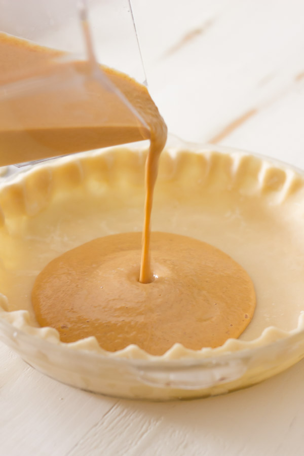 Pie Crust Tutorial Step 9 - pumpkin filling being poured into the frozen, unbaked crust.