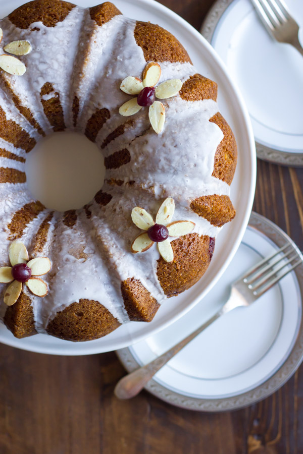 Cranberry Almond Greek Yogurt Cake on a cake stand, with plates and forks next to it.  