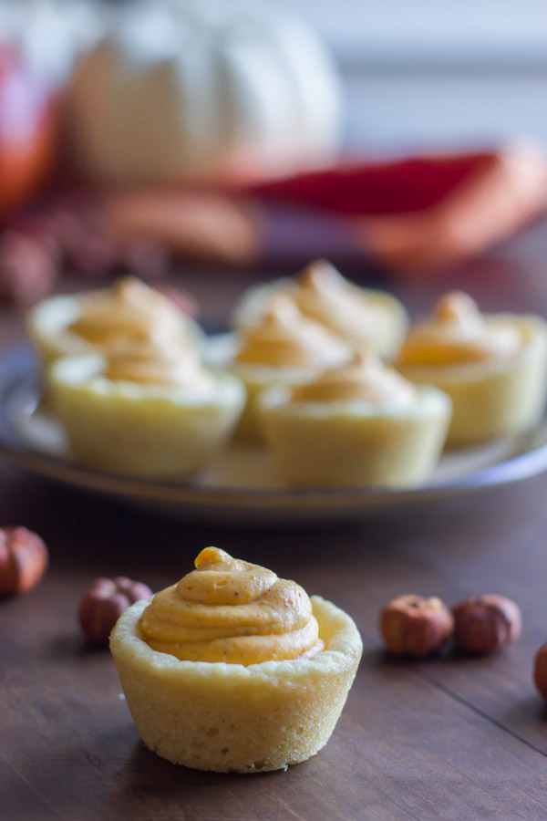 Easy Mini Pumpkin Pie Tart with a plate of more tarts in the background.