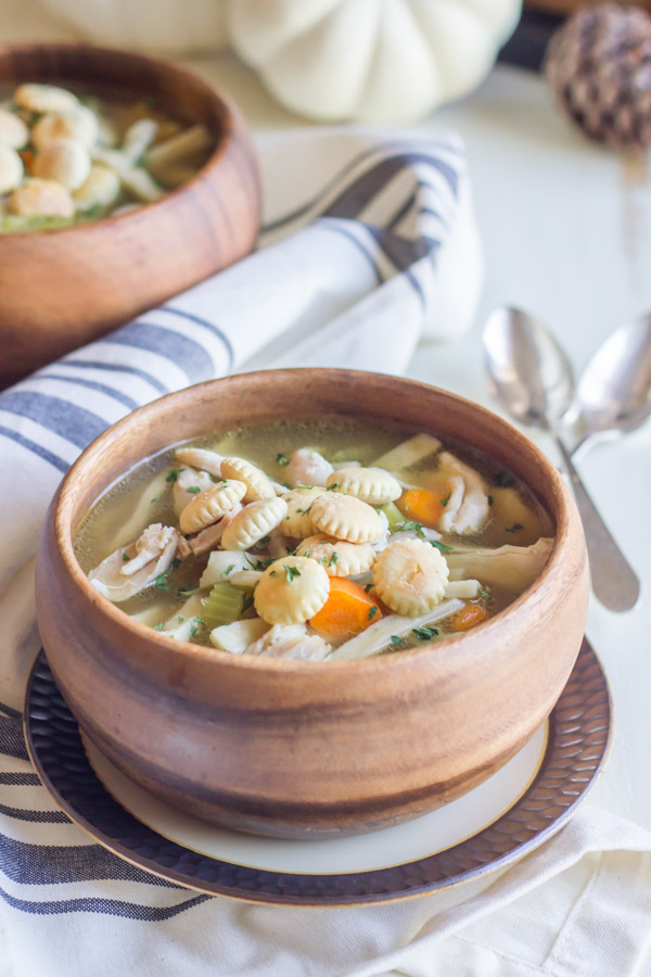 Homemade Chicken Noodle Soup in a bowl, topped with oyster crackers.  