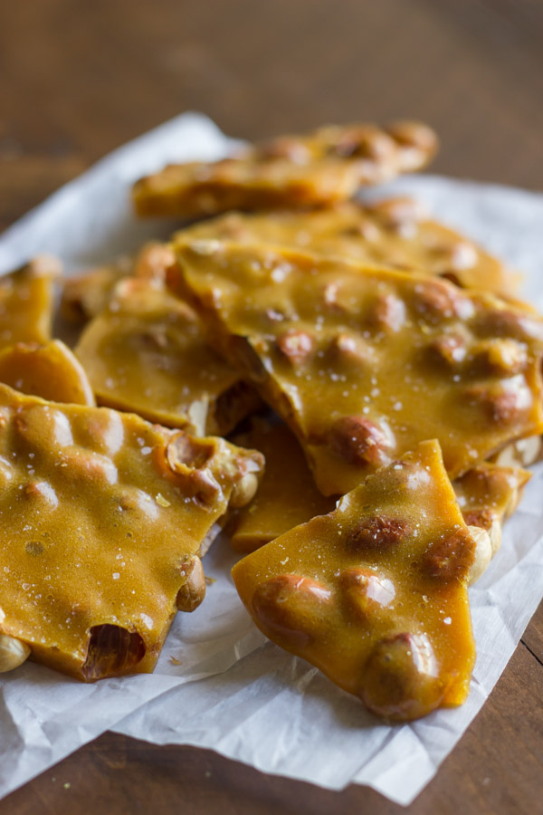 Peanut Brittle pieces piled on parchment paper.