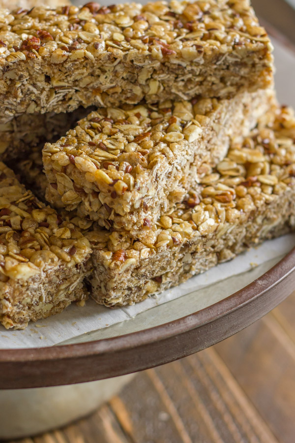 Healthy Chewy Apple Cinnamon Granola Bars stacked on a piece of parchment paper.  