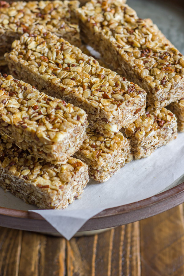 Healthy Chewy Apple Cinnamon Granola Bars stacked on a piece of parchment paper.  