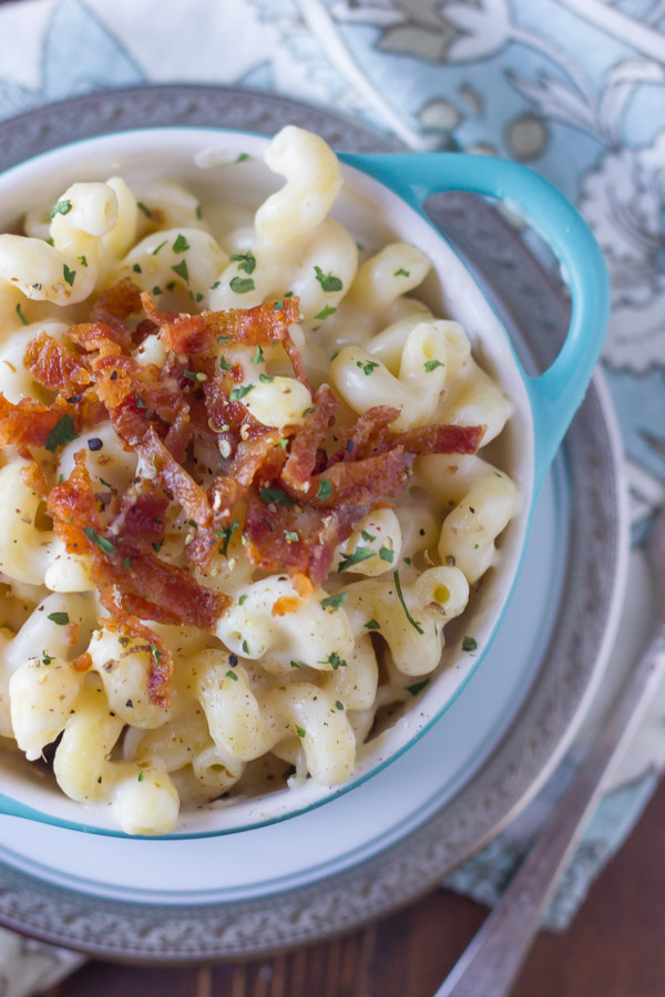 Creamy Mac and Cheese With Bacon in a bowl that is sitting on a plate.  