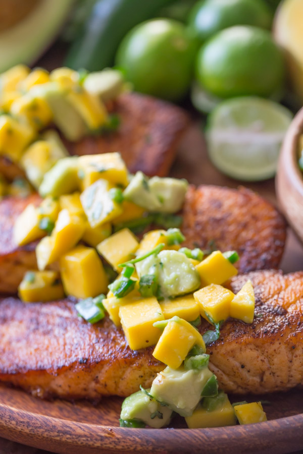 Chili Lime Salmon With Mango Avocado Salsa on a wood plate.