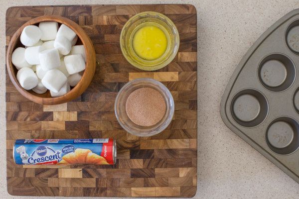 Empty Tomb Roll ingredients on a cutting board next to a muffin tin.  