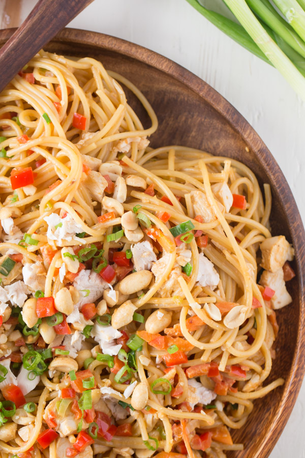 Easy Spicy Peanut Noodles With Chicken on a wood serving plate.