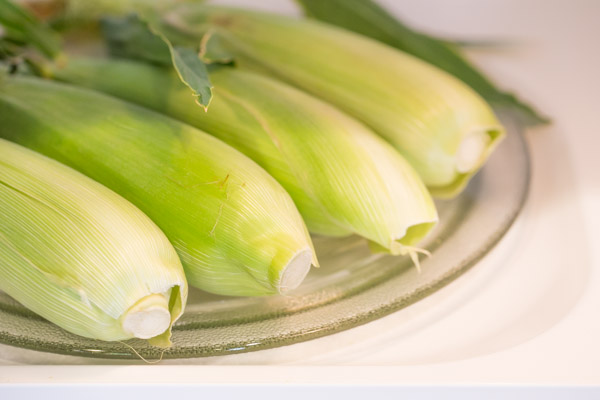 Four ears of corn in the microwave.  