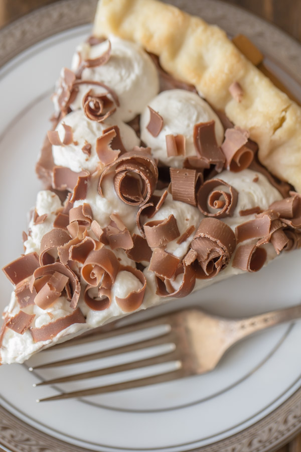 Homemade Chocolate Pudding Pie - Rich, creamy homemade chocolate pudding topped with whipped cream and piled with milk chocolate curls.