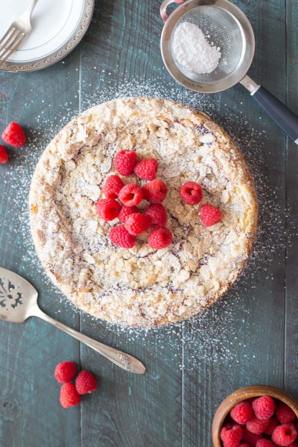 Raspberry Almond Coffee Cake garnished with powdered sugar and fresh raspberries.