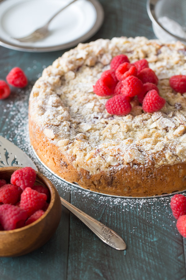 Raspberry Almond Coffee Cake garnished with powdered sugar and fresh raspberries.