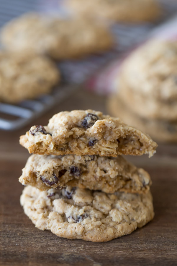 A Pumpkin Pie Spice Oatmeal Raisin Cookie broken in half and stacked on top of a whole cookie.  