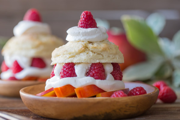 Raspberry Peach Shortcakes assembled on wood plates.
